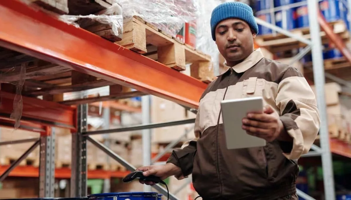 Operario de una distribuidora controlando mercadería en el depósito con una tablet