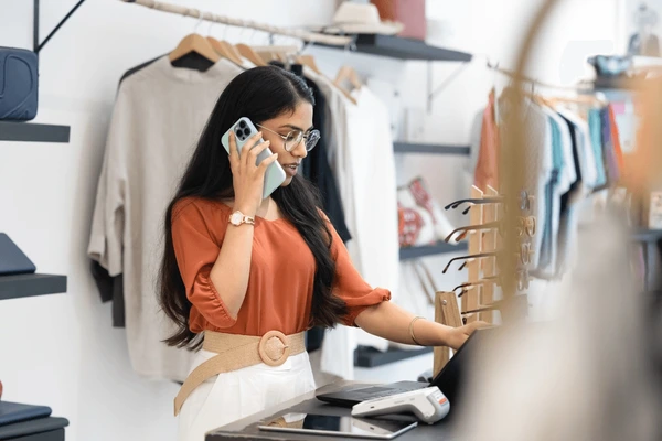 Encargada de una tienda de ropa revisando prendas en el local