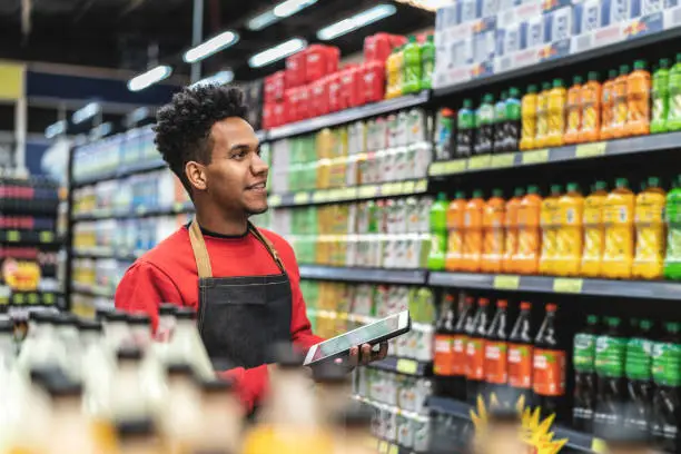 Repositor controlando precios en la góndola de un supermercado